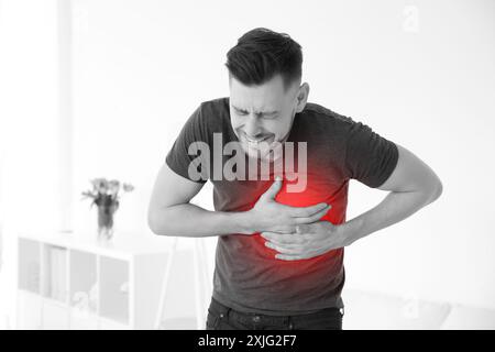 Man suffering from pain in chest at home. Heart disease Stock Photo