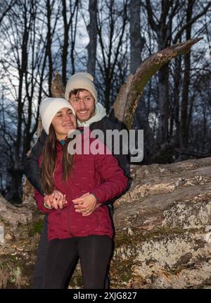 mountain couple hugging leaning on a log Stock Photo