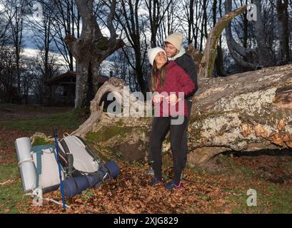 mountain couple hugging leaning on a log Stock Photo