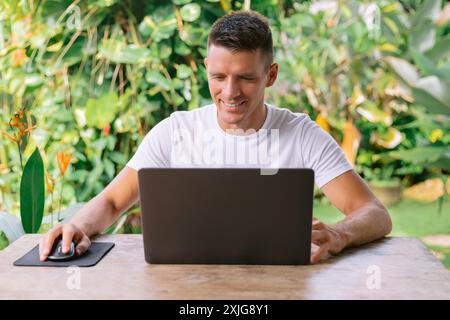 Portrait of a cheerful caucasian man having a video call on his laptop. Stock Photo