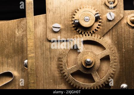 Vintage clock details close-up photo with selective focus, gears made of brass are on a backside of a mantel clock Stock Photo