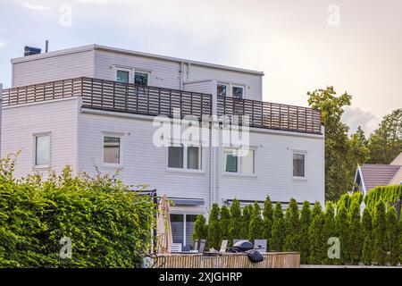 Beautiful view of modern European wooden villa painted white with garden and patio. Sweden. Stock Photo