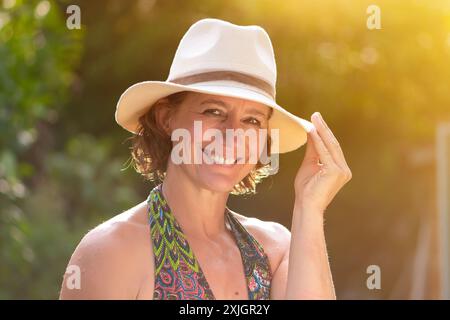 Woman Wearing a White Hat Smiles on a Sunny Day Stock Photo