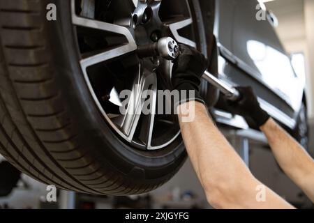 Mechanic working on car tire in auto repair shop Stock Photo