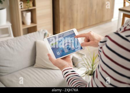 Young man using smart home security system control panel, closeup Stock Photo