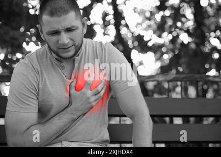 Man suffering from pain in chest outdoors. Heart disease Stock Photo