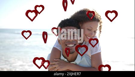 Image of hearts moving over diverse couple in love on beach in summer. Love, romance, valentine's day and vacation concept digitally generated image. Stock Photo