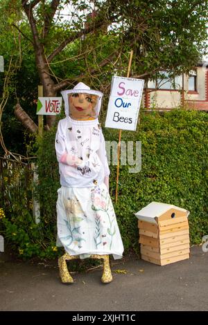 'Save our bees'   Create a honey bee haven, grow bee-friendlu plants. Wildlife plea sign on Dummy in beekeeper suit  Penwortham, Preston, UK Stock Photo