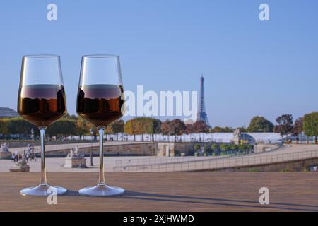 Romantic dinner. Two glasses of red wine on Eiffel tower and Paris skyline background. Stock Photo