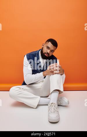 African American man sits gracefully with hands clasped in deep thought. Stock Photo