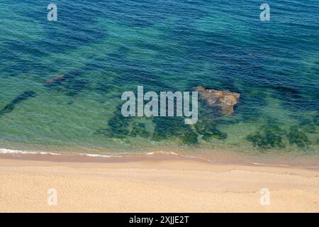 Soft blue ocean wave on clean sandy beach Stock Photo