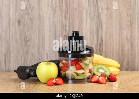 Hand blender kit, fresh fruits and strawberries on wooden table Stock Photo