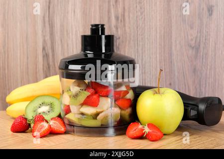 Hand blender kit, fresh fruits and strawberries on wooden table Stock Photo