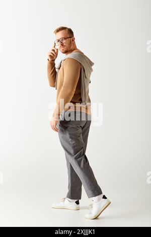 Stylish man walking, white backdrop. Stock Photo