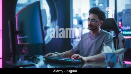 Software Developer Wearing Sci-Fi Monocle with Augmented Reality and Artificial Intelligence Functions. Young Handsome Man Working on a Computer in a Futuristic Cyber Reality Agency Room Stock Photo