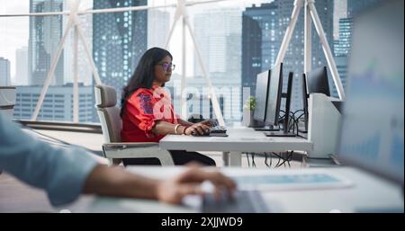 Portrait of a Young Indian Female Working with a Talented Team of Male Professionals in a Technological Research and Development Agency. Group of Businesspeople Dealing with Financial Projects Stock Photo