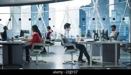 Team of Talented Young Indian Professionals Working in a Business Research and Development Agency. Desktop Computer Screens Showing Analytical Data, Research Reports and Diagrams Stock Photo