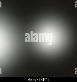 Grainy texture with two light spots creating a gradient on a dark background abstract concept Stock Photo