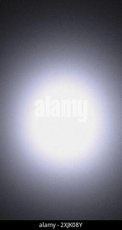 Abstract background with grainy texture forming a white circle on a black background Stock Photo