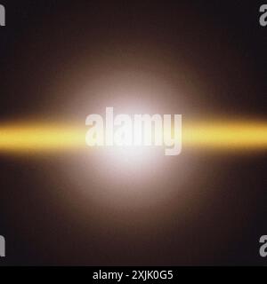 Bright yellow beam of light is shining on a dark background with a grainy texture Stock Photo