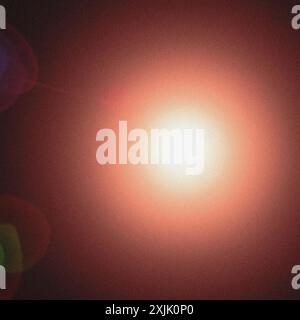 Abstract background with a bright light shining on a grainy dark red background Stock Photo