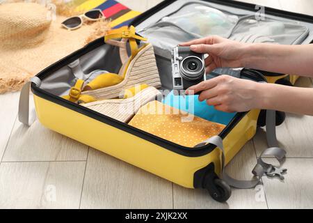 Woman packing suitcase for trip at home, closeup Stock Photo