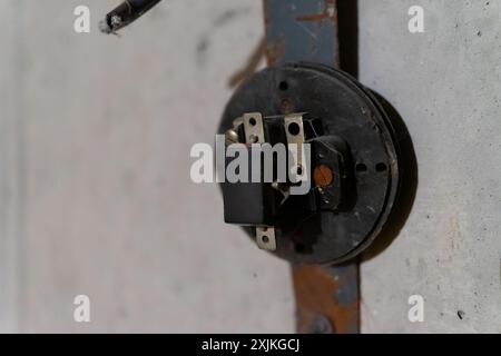 Disassembled antique light switch on a concrete wall. Copy space. Stock Photo