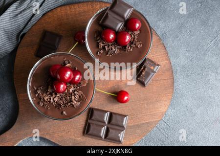 Chocolate cocoa pudding with sour cherry, mousse in glass cup on rustic table, supangle Stock Photo