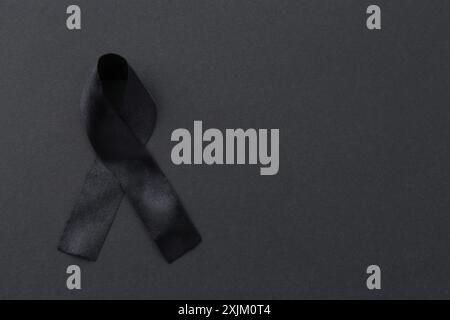 Black awareness ribbon on color background, top view. Space for text Stock Photo