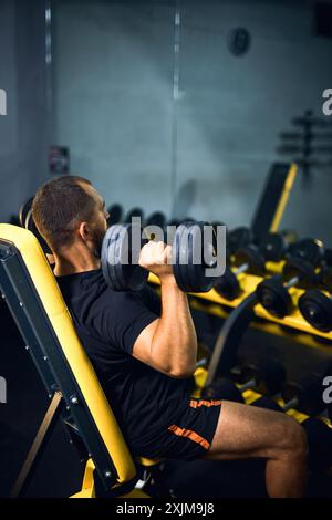 Middle age man with dumbbells flexing muscles in gym - sport, fitness, bodybuilding, lifestyle and people concept Stock Photo