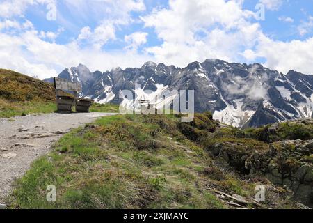 View of two wooden benches on a high mountain path Stock Photo