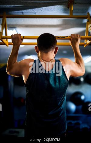 Back view of a strong man doing pull ups in a gym. Fitness and bodybuilding training health lifestyle concept Stock Photo