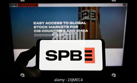 Stuttgart, Germany, 06-18-2022: Person holding smartphone with logo of Russian financial marketplace SPB Exchange on screen in front of website. Stock Photo