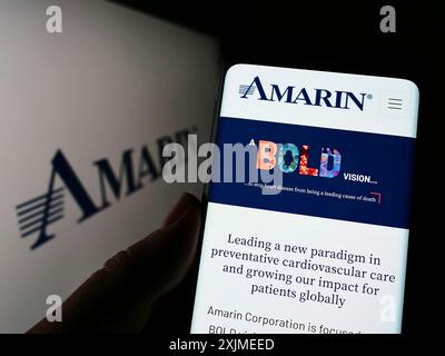 Stuttgart, Germany, 06-11-2022: Person holding cellphone with website of biopharmaceutical company Amarin Corporation plc on screen with logo. Focus Stock Photo