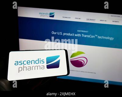 Stuttgart, Germany, 06-11-2022: Person holding cellphone with logo of biotechnology company Ascendis Pharma AS on screen in front of business Stock Photo