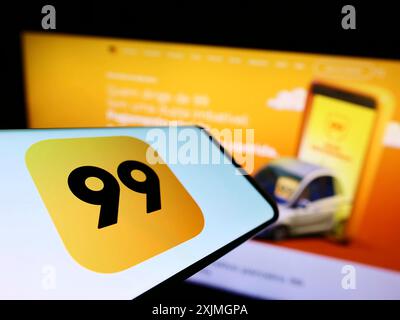 Stuttgart, Germany, 07-16-2022: Smartphone with logo of Brazilian company 99 Tecnologia Ltda. (99app) on screen in front of website. Focus on Stock Photo