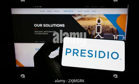 Stuttgart, Germany, 07-16-2022: Person holding cellphone with logo of American information technology company Presidio Inc. on screen in front of Stock Photo