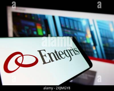 Stuttgart, Germany, 07-16-2022: Mobile phone with logo of American microelectronics company Entegris Inc. on screen in front of website. Focus on Stock Photo