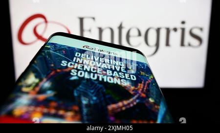 Stuttgart, Germany, 07-16-2022: Smartphone with website of US microelectronics company Entegris Inc. on screen in front of business logo. Focus on Stock Photo