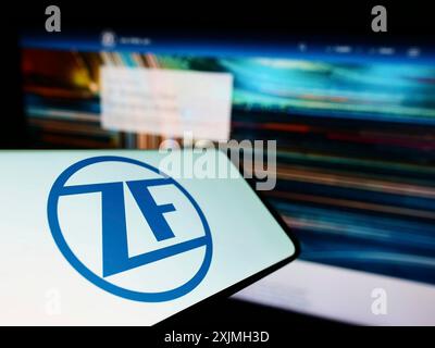 Stuttgart, Germany, 07-16-2022: Smartphone with logo of automotive company ZF Friedrichshafen AG on screen in front of business website. Focus on Stock Photo