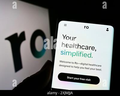 Stuttgart, Germany, 07-31-2022: Person holding cellphone with webpage of telehealth company Roman Health Ventures Inc. (Ro) on screen with logo. Stock Photo