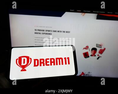 Stuttgart, Germany, 07-31-2022: Person holding cellphone with logo of Sporta Technologies Private Limited (Dream11) on screen in front of webpage. Stock Photo