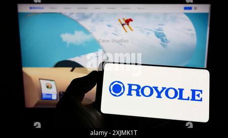 Stuttgart, Germany, 07-31-2022: Person holding smartphone with logo of display manufacturing company Royole Corporation on screen in front of Stock Photo