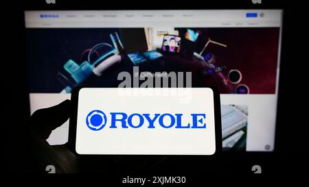 Stuttgart, Germany, 07-31-2022: Person holding cellphone with logo of display manufacturing company Royole Corporation on screen in front of webpage. Stock Photo