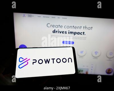 Stuttgart, Germany, 07-31-2022: Person holding cellphone with logo of British animation software company Powtoon.com Inc. on screen in front of Stock Photo