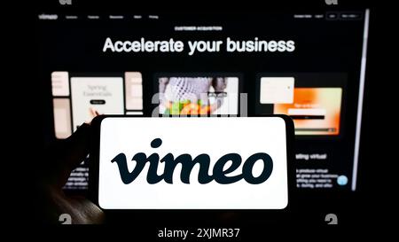 Stuttgart, Germany, 10-01-2022: Person holding smartphone with logo of video hosting company Vimeo.com Inc. (Vimeo) on screen in front of website. Stock Photo