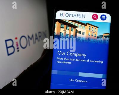 Stuttgart, Germany, 10-02-2022: Person holding cellphone with webpage of US company BioMarin Pharmaceutical Inc. on screen in front of logo. Focus on Stock Photo