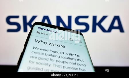 Stuttgart, Germany, 10-27-2022: Mobile phone with webpage of Swedish construction company Skanska AB on screen in front of business logo. Focus on Stock Photo