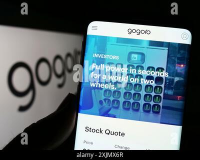 Stuttgart, Germany, 12-10-2022: Person holding smartphone with webpage of Taiwanese electric mobility company Gogoro Inc. on screen with logo. Focus Stock Photo