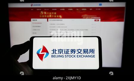 Stuttgart, Germany, 12-25-2022: Person holding smartphone with logo of Chinese company Beijing Stock Exchange (BSE) on screen in front of website. Stock Photo